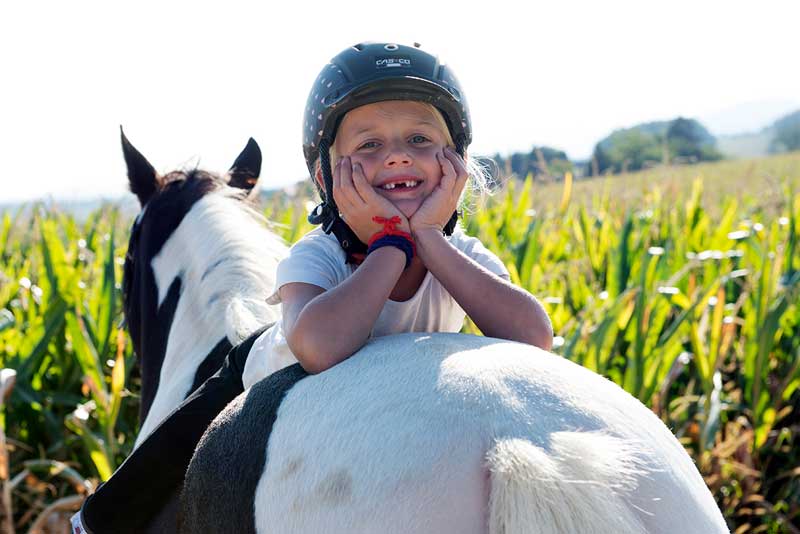 Kind auf dem Pony am lachen